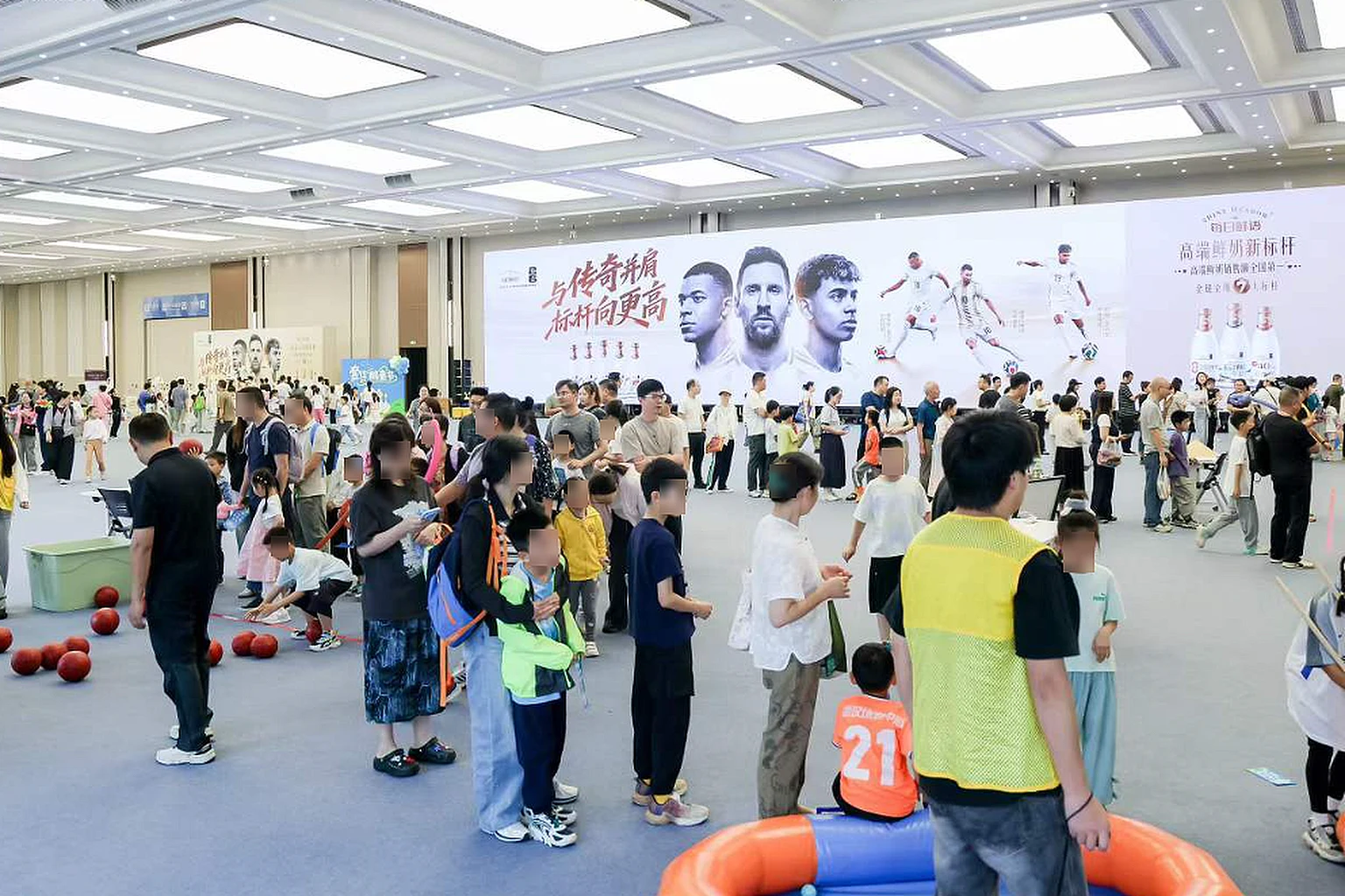 大型场馆内举办的品牌活动现场，众多参与者在场地中聚集